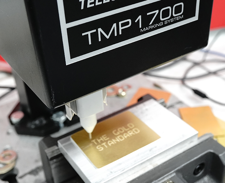 Telesis Pinstamp TMP1700 Marking System marking gold to say "The Gold Standard"