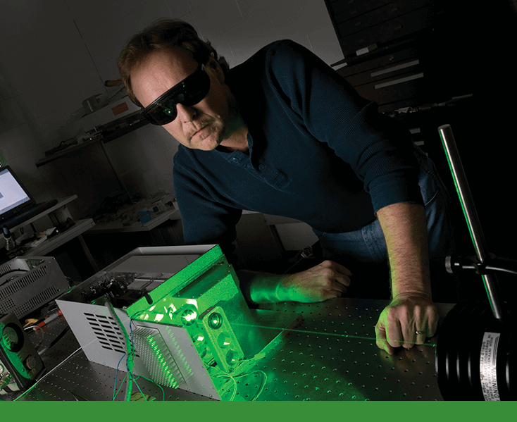 Man looking over a green laser
